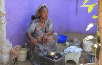 In the highlands of Abyssinia, in the village of Sina, young woman roasting coffee for the coffee