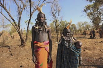 Southern Ethiopia, in Maco National Park, Mursi tribe, Mursi man, Mursi woman with baby, painted