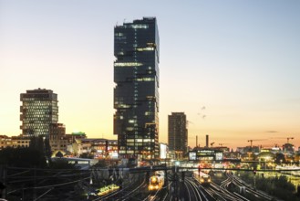 Sunset at the Modersohn Bridge, view of railway tracks, trains and the 140 metre high Amazon office