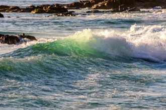 Small waves breaking on the beach in Salvador, Bahia during sunset, Salvador, Bahia, Brazil, South