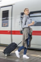 Young woman on the railway track while a train arrives