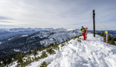 Ski tourer at the summit of the Simetsberg with summit cross, mountain panorama, Estergebirge,