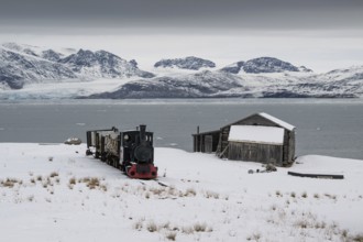 Historic mine railway in front of the wintery, snow-covered Kongsfjorden, Ny-Ålesund, Spitsbergen