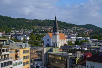 City of Molde with cathedral church and houses as well as mountains and sky in the background,