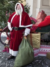 Father Christmas with sack in front of sleigh