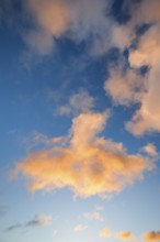 Orange spring clouds adorn the blue morning sky at sunrise