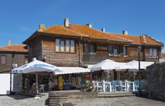 Restaurant with open-air tables next to souvenir shops in a traditional wooden building, Black Sea,