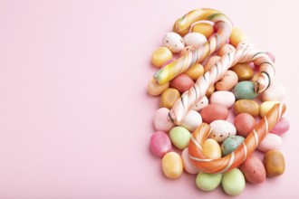 Various caramel candies on pink pastel background. copy space, side view