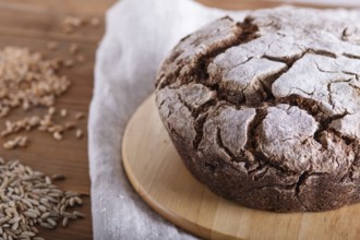 Yeast free homemade bread with whole rye and wheat grains on rustic wooden background. close up