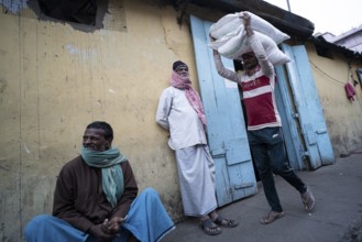 Labourer carries good from truck at a wholesale market, ahead of the presentation of the Interim