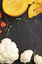 Pumpkin, cauliflower, pea sprouts on a black concrete background. Top view, flat lay, copy space