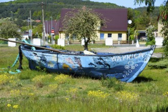 A weathered boat in a meadow with a village in the background, Wapnica, Wollin Island, Wolin, West