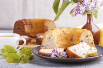 Cakes with raisins and chocolate and a cup of coffee. lilac flowers on a gray concrete background,