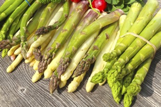 Green asparagus and white asparagus decorated on a rustic wooden table