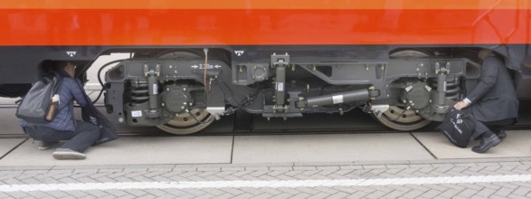 Chinese visitors to the InnoTrans trade fair in Berlin take a look at the undercarriage under a