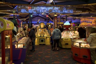 People playing on machines, Electric Palace amusement arcade, Weymouth, Dorset, England, United