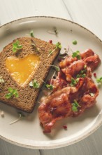 Breakfast, fried egg with bacon, micro-green, on a light background, no people, selective focus