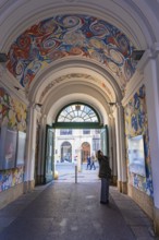 A visitor looks at the ceiling painting of a passage in the Museumsquartier, Vienna, Austria,