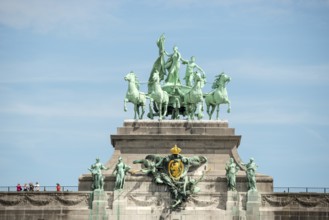 Monumental sculpture group on a triumphal arch in front of a blue sky, quadriga, close-up, people,