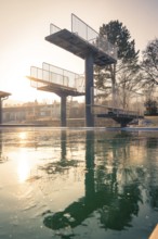 Diving tower with steps in the outdoor pool, immersed in soft evening light with frozen water, ENCW