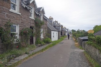 Narrow village street with traditional houses and green surroundings on a cloudy day, Iona, Inner