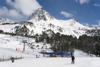 Skifahrer in einem Andorra-Skigebiet mit schneebedeckten Bergen, Pisten und klarem Himmel,