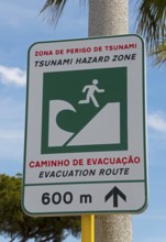 Warning sign for a tsunami danger zone near the beach with evacuation notice, Vilamoura, Faro,