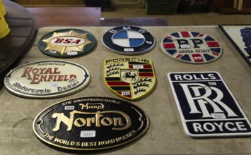 Replica reproduction metal signs related to motoring brands on display at auction, UK