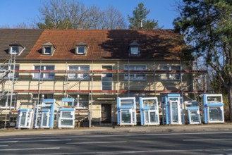 Energy-efficient refurbishment of residential buildings, older apartment block is scaffolded, gets