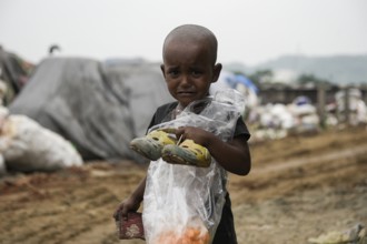 A child crying at a garbage dumpsite on the eve of World Environment Day, in Guwahati, Assam, India