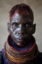 Portrait of a woman from the Turkana tribe, Kenya. Her face is smeared with ochre