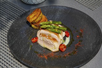 Tuna steak with green asparagus, fried potatoes served on a plate, main course, fish dish, Hotel