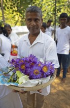 Sri Lankan pilgrim with purple lotus flowers, Holy City of Anuradhapura, North Central Province,