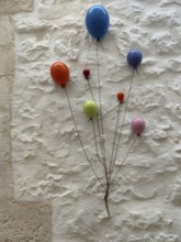 Colourful ceramic balloons as decoration on a white house wall, Cisternino, southern Italy, Italy,