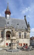 Statue of Jacob van Maerlant in front of Brabantine Gothic town hall in the city Damme in summer,