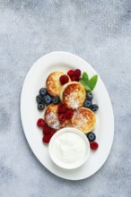 Breakfast, cottage cheese cakes, with fresh berries, and sour cream, top view, close-up, no people