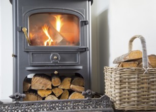 Warm fire flames logs burning in ClearView domestic multifuel stove burner inside home, UK