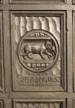 Historic carved wooden panel on door of house in Marlborough, Wiltshire, England, UK commemorates