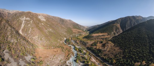 Aerial view, mountain stream Ala Archa flows through the Ala Archa valley, autumnal mountain