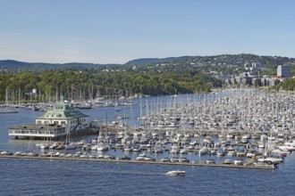 Marina with numerous boats and surrounded by urban and forest landscapes, capital city, Oslo,