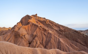 Erosion landscape of red sandstone, rock formations at sunrise, Skazka Canyon Fairytale gorge,