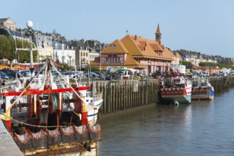 Colourful boats at the edge of the harbour against the backdrop of a historic coastal town, fishing