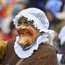 Person masked as a grandmother at the carnival parade of the Wey guild on Rose Monday, Güdismäntig,