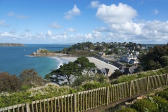 Panorama of a coastal town with houses on the beach, blue sky and trees, view of sandy beach