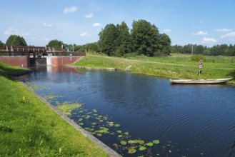 A lock is located on a river with water lilies, surrounded by green nature, Tartak Lock, Augustow