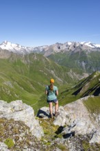 Mountaineer sitting on a rock in front of a mountain panorama with Großvenediger, mountain