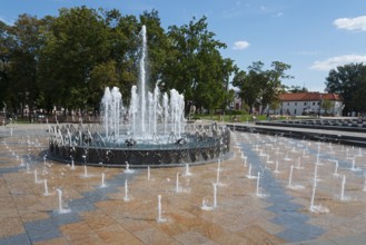 Large fountain with bubbling water in the centre of a park, Litewski Square, Lithuanian Square,