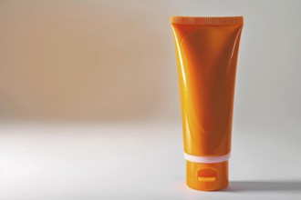 Orange sunscreen tube on white studio background with copy space. KI generiert, generiert, AI