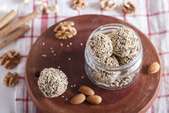 Energy balls cakes with almonds, sesame, cashew, walnuts, dates and germinated wheat on wooden