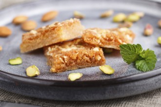 Traditional arabic sweets in gray ceramic plate on a gray concrete background. side view, close up,